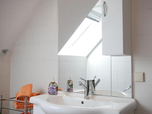 a white bathroom with a sink and a skylight at Haus Philipp in Bad Urach