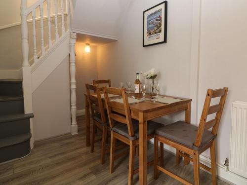 a dining room with a wooden table and chairs at Harbourside Cottage in Torquay