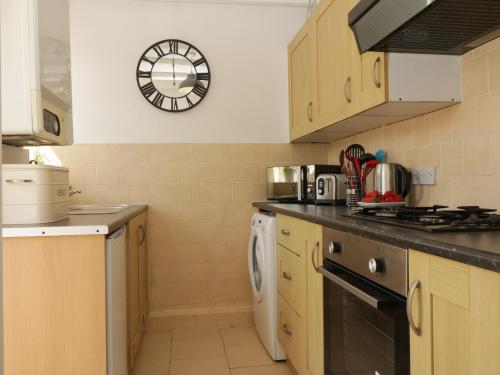 a kitchen with a stove and a dishwasher at Harbourside Cottage in Torquay