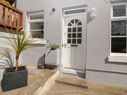 a house with a plant in front of a door at Harbourside Cottage in Torquay