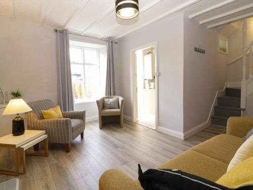 a living room with a couch and chairs and a table at Harbourside Cottage in Torquay