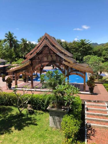 a wooden bridge over a pool in a resort at Le Palais Juliana in Luang Prabang