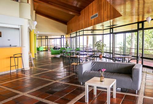 a lobby with a couch and tables and chairs at HI Almada - Pousada de Juventude in Almada