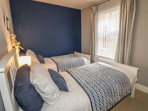 two beds in a room with blue walls at 1 The Moorings in Newry