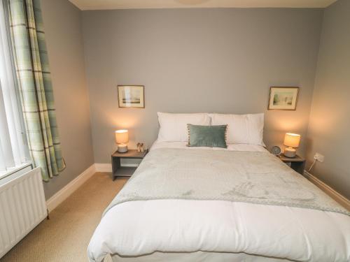 a bedroom with a large white bed with two lamps at 1 The Moorings in Newry