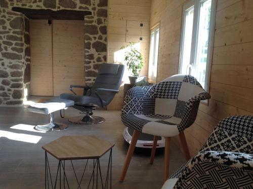 a living room with chairs and a table at LES ROCAILLES in La Forêt-Auvray