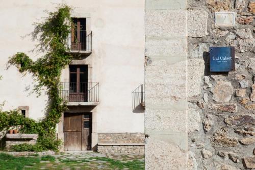 a building with a sign on the side of it at Cal Calsot Casa Rural "Adults Only" in Montellá