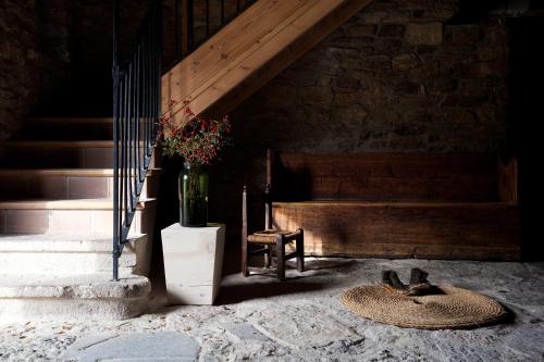a room with a staircase and a vase with flowers in it at Cal Calsot Casa Rural "Adults Only" in Montellá