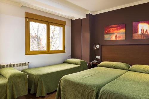 A bed or beds in a room at Hotel San Lázaro