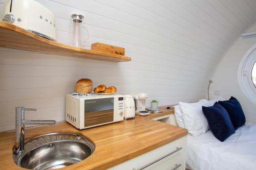a kitchen with a sink and a microwave and a bed at Samphire Ark 900 in Emsworth
