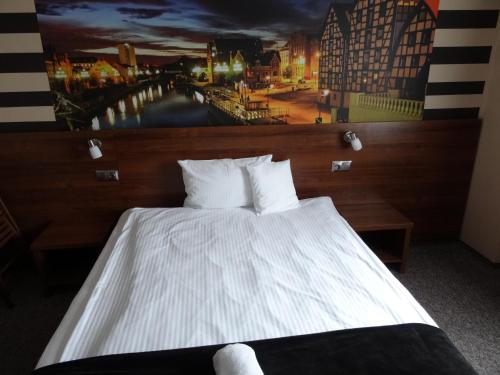 a bedroom with a bed with a painting on the wall at Pro B&B in Osielsko