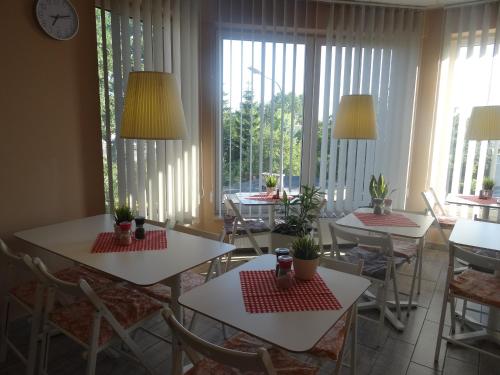 a dining room with tables and chairs and windows at Pro B&B in Osielsko