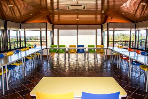 a cafeteria with tables and chairs and windows at HI Almada - Pousada de Juventude in Almada