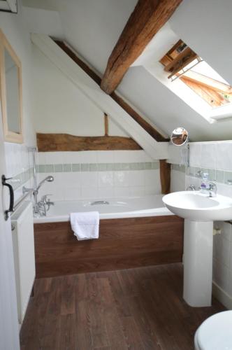 a bathroom with a bath tub and a sink at Whitewells Farm Cottages in Great Malvern