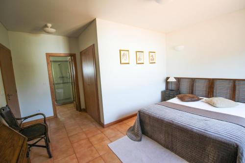 a bedroom with a bed and a chair in it at Quinta da Aldeia de Avanca in Avanca