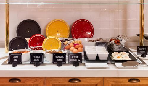 a table with plates and bowls of food on it at H10 Casa de la Plata in Seville