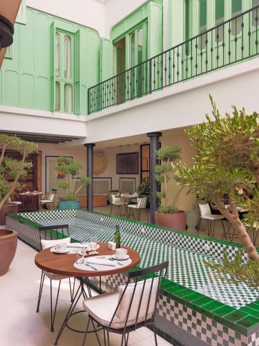 an outdoor patio with tables and chairs and plants at H10 Casa de la Plata in Seville