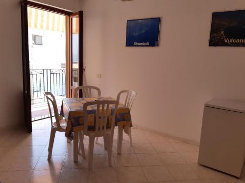 a dining room with a table and chairs and a television at Baia Unci in Canneto