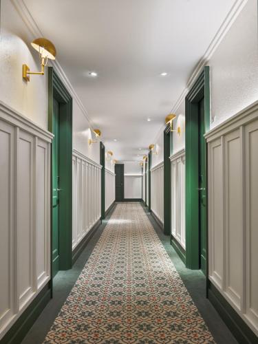a hallway with green doors and a carpet at H10 Casa de la Plata in Seville
