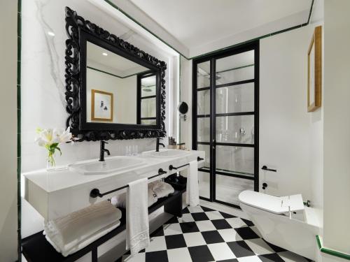 a bathroom with a black and white checkered floor at H10 Casa de la Plata in Seville