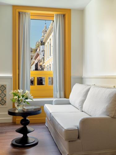 a living room with a couch and a window at H10 Casa de la Plata in Seville