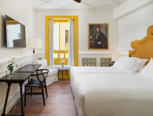 a hotel room with a bed and a table at H10 Casa de la Plata in Seville