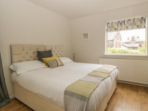 een slaapkamer met een groot wit bed en een raam bij Bay View Cottage in Newport-On-Tay