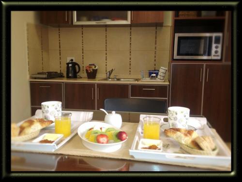 Una mesa con dos bandejas de comida y bebidas en una cocina. en Giova Apart Salta, en Salta
