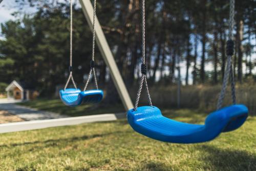 two swings hanging in a park at Ramios bitės in Palanga