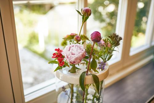 a vase filled with flowers on a window sill at Rochter Landhotel in Zeltingen-Rachtig