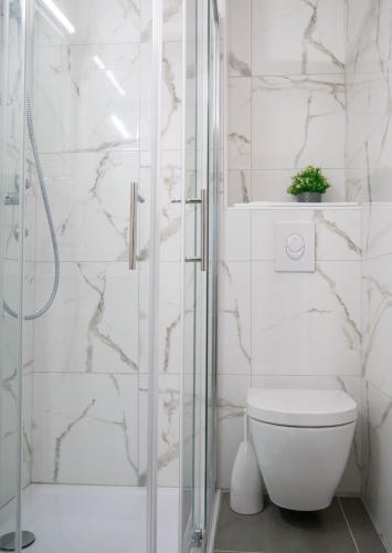 a white bathroom with a toilet and a shower at Hotel Vienna in Zagreb
