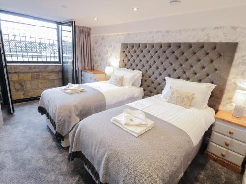 a hotel room with two beds with towels on them at Olton Hall Engine Shed in Whitby