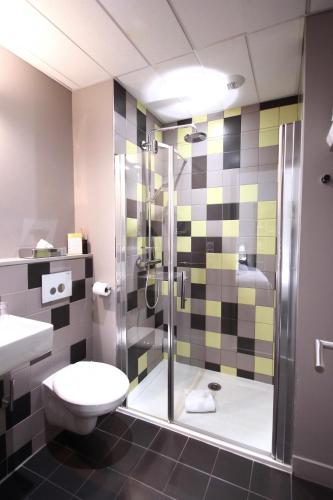 a bathroom with a shower and a toilet and a sink at Hôtel de Tourny - Boutique Hôtel Bordeaux Centre in Bordeaux
