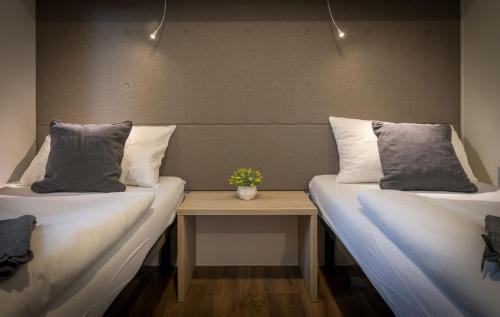 two beds with pillows and a table in a room at Apartments and Mobile Homes Makarska in Makarska