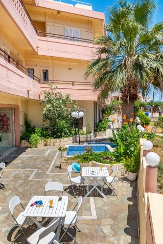 a patio with tables and chairs and a pool at Louladakis Apartments in Kolymvari