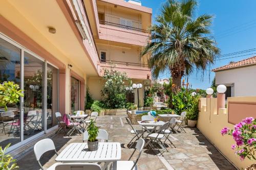 a patio with tables and chairs and a building at Louladakis Apartments in Kolymvari
