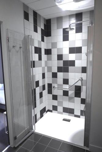 a bathroom with a shower with black and white tiles at Hôtel de Tourny - Boutique Hôtel Bordeaux Centre in Bordeaux