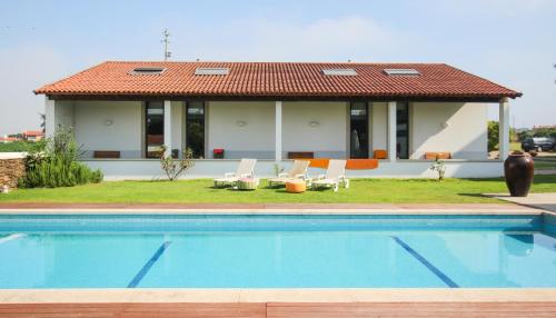 a house with a swimming pool in front of a house at Quinta da Aldeia de Avanca in Avanca
