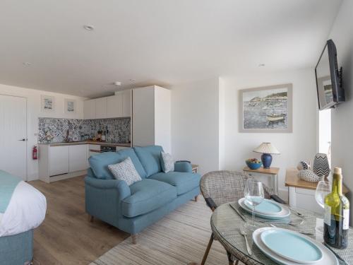 a living room with a blue couch and a table at 6 The Beaches in Weymouth