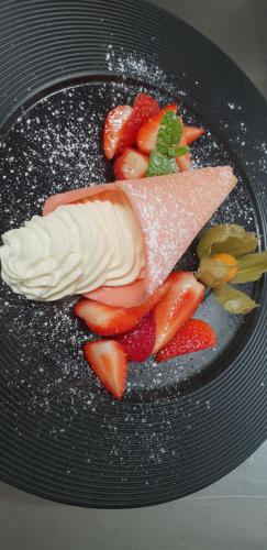 a plate of food with fruit and ice cream at Schlosstaverne Lunz in Lunz am See