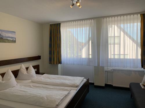 a hotel room with two beds and a window at Hotel Lindenhof in Mosbach