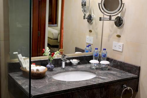 um balcão de casa de banho com um lavatório e um espelho em Avari Xpress Multan em Multan