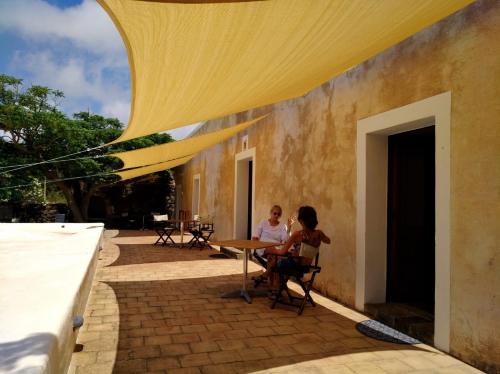 two people sitting at a table on a patio at 2 Gatti - Sogno in Pantelleria
