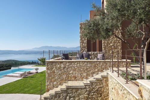 a villa with a stone wall and a pool at Villa Niolos II in Stérnai