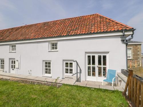 a white house with a blue chair in the yard at Avonside Cottage in Bristol