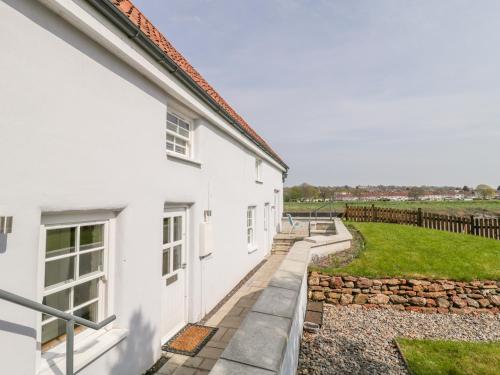 a white house with a garden next to it at Avonside Cottage in Bristol