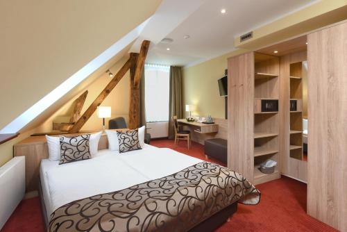 - une chambre avec un lit et un bureau dans l'établissement Port Inn Hotel, à Eichwalde