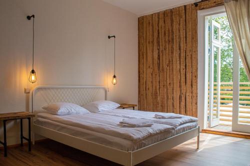 a bedroom with a bed and a large window at Taevas Külalistemaja in Võru