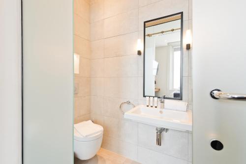 a bathroom with a toilet and a sink and a mirror at Templebar Rooms in Dublin