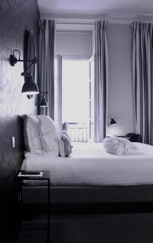 a bedroom with a large bed with a window at Hôtel de Tourny - Boutique Hôtel Bordeaux Centre in Bordeaux